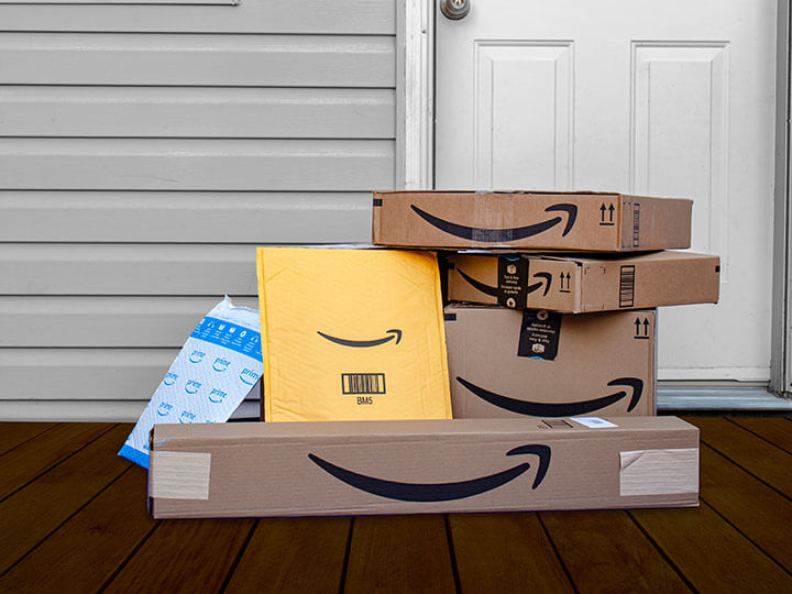Variety of Amazon delivery boxes and envelopes by a front door