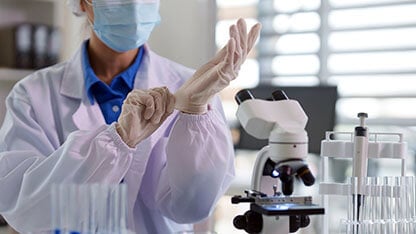 Asian adult scientist preparing laboratory work putting on sterile gloves medical research experiment safety focus