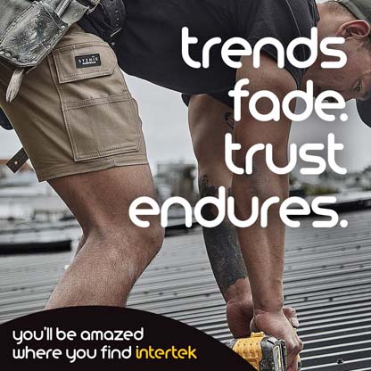 A construction worker leaning over to drill into a roof-top structure